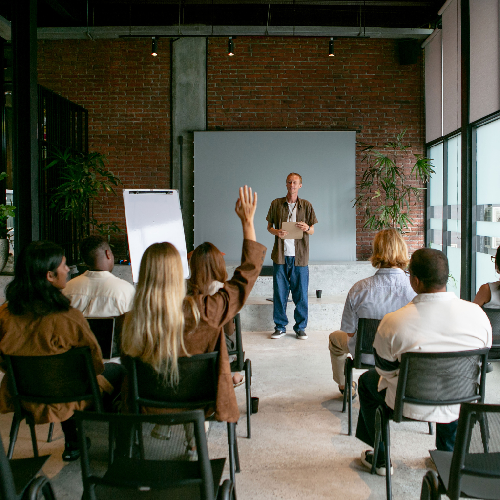 Person in the front of the room teaching a group of people